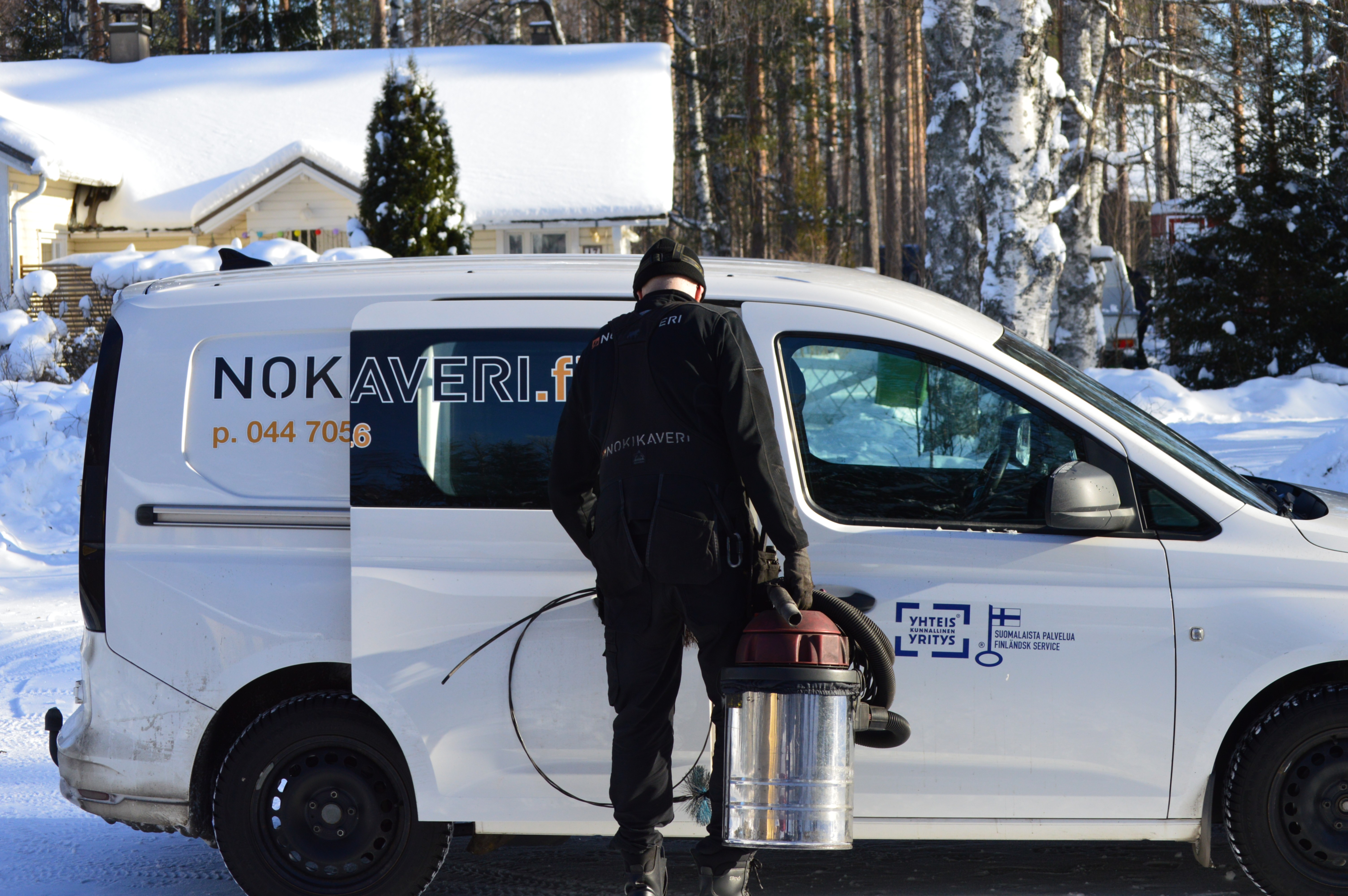 Nuohooja ottamassa välineitä autosta